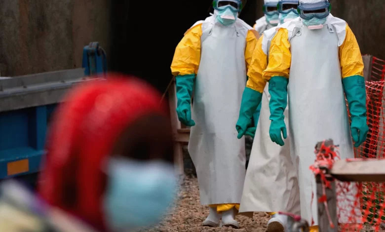 Healthcare workers in protective gear treating Ebola patients in an eastern DRC clinic