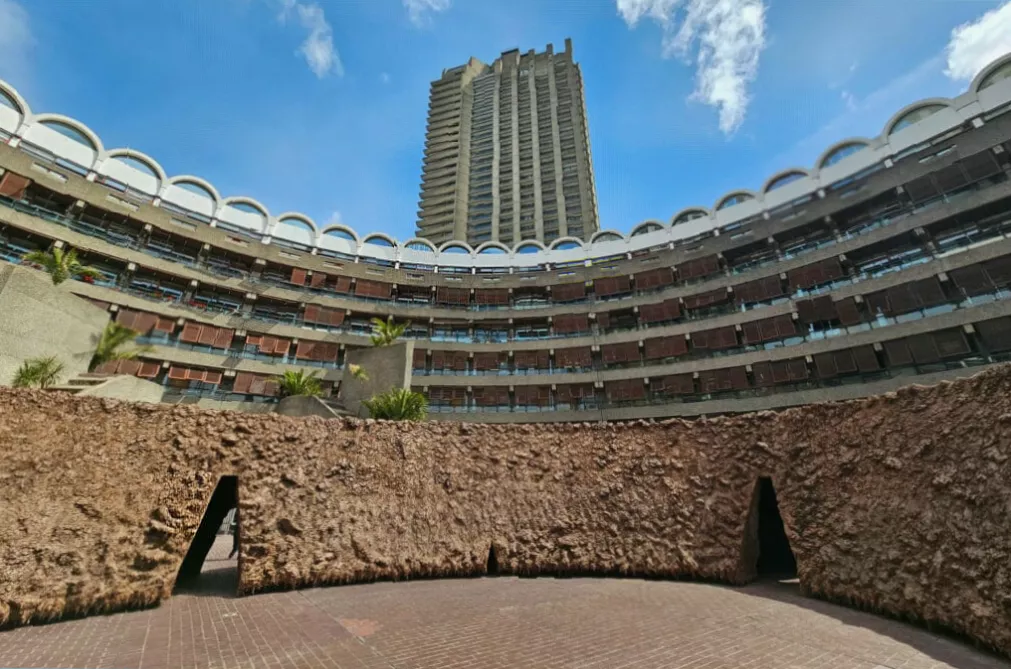 Narrow cave-like entrance into the earthy doughnut-shaped installation