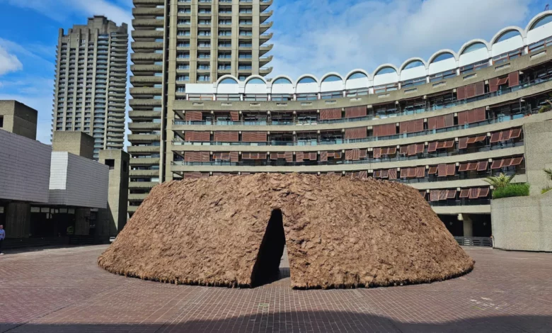 Large oval mud sculpture filling the Barbican's third-floor Sculpture Court