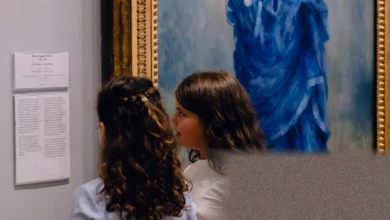 A young child points at a painting in a quiet art gallery