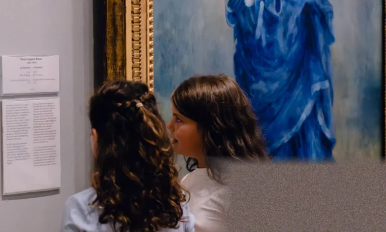 A young child points at a painting in a quiet art gallery