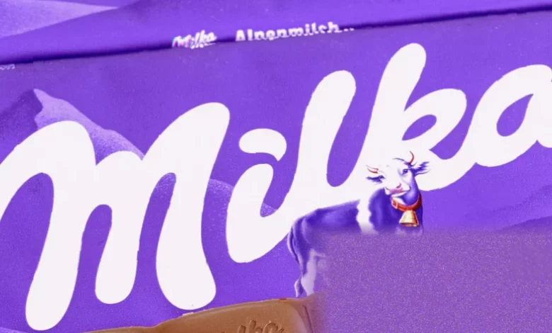 A purple Milka chocolate bar displayed next to a smaller version on a supermarket shelf
