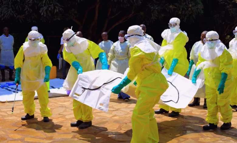 A health worker in protective gear stands outside an Ebola treatment centre in a rural Congolese village.