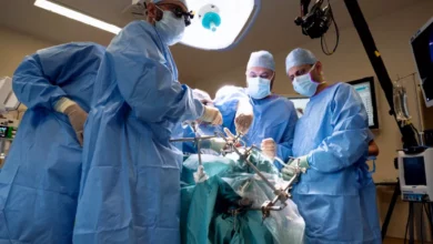 Surgeon consulting a 3D-printed model of a patient's skull and eye socket before surgery.