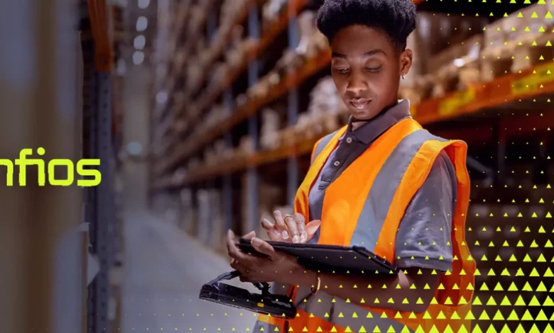 Warehouse workers monitoring automated supply chain systems on digital screens