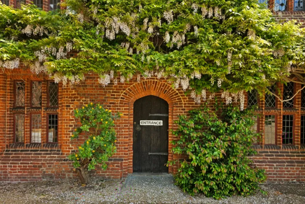 Hidden priest hole chamber behind a wooden panel inside a historic English house