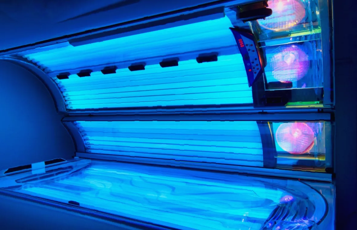 A box of sunbed goggles and a timer remote sitting on a sunbed cushion