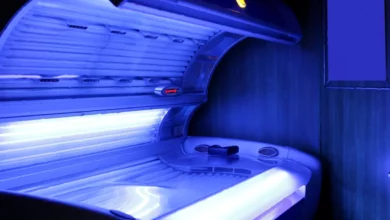 A sunbed salon with an unattended contactless payment kiosk in a dimly lit room