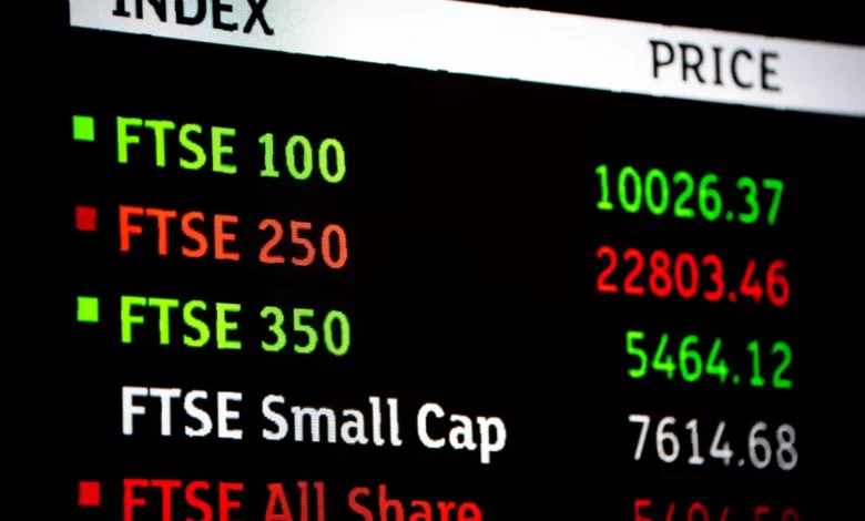 Traders on the London Stock Exchange floor watching screens show falling FTSE 100 index figures
