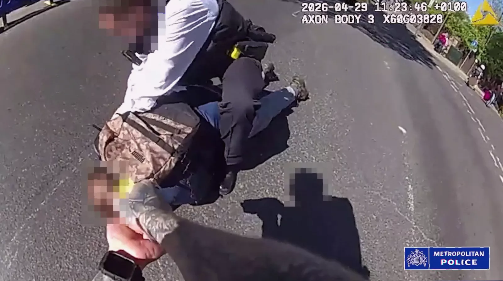 A Metropolitan Police Taser being held by an officer on a residential street