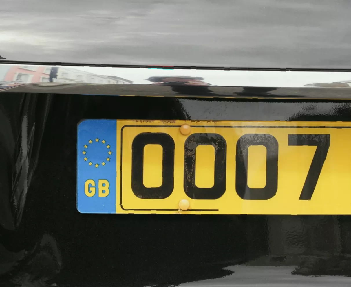 Close-up of tamper-resistant screws being fitted to a vehicle number plate