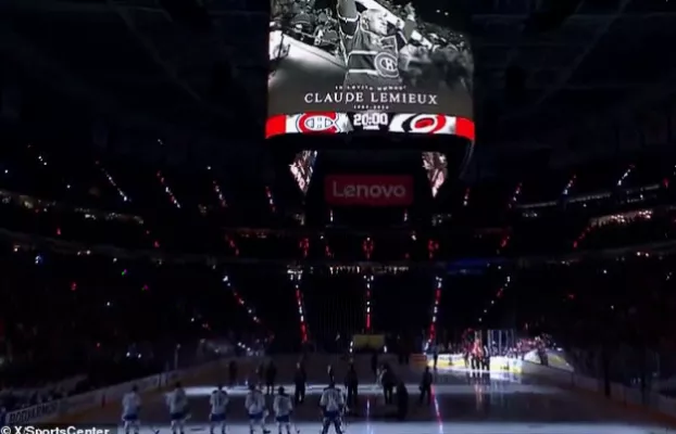 Television screen showing a tribute portrait of a former NHL player at a sports venue