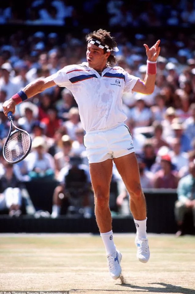 A junior tennis player practising alone on a worn-out court