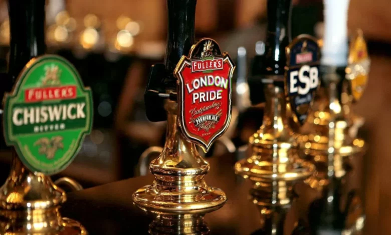 A pint of lager on a bar counter in a London pub with a price tag beside it.