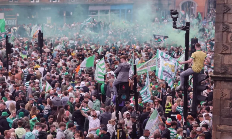 Police officers stand near the pitch at Celtic Park after fans stormed the field following the title win.