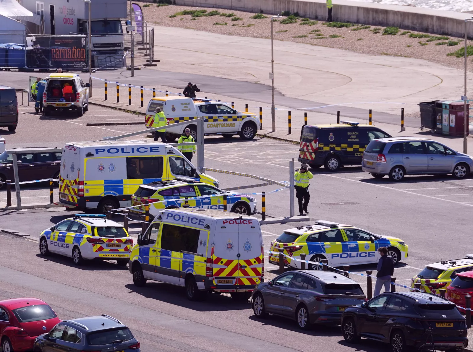 Evening view of Brighton seafront with police vehicles and rescue craft near the shoreline