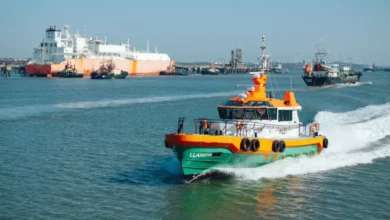 Cargo vessels moored at Milford Haven waterfront with industrial port infrastructure in background