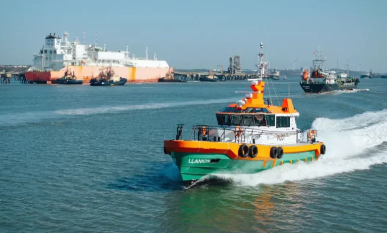 Cargo vessels moored at Milford Haven waterfront with industrial port infrastructure in background