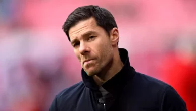Xabi Alonso holding a Chelsea scarf at a press conference