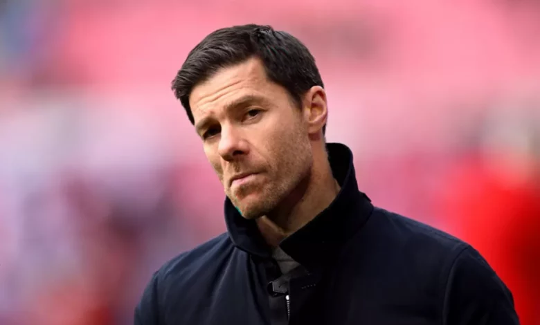 Xabi Alonso holding a Chelsea scarf at a press conference