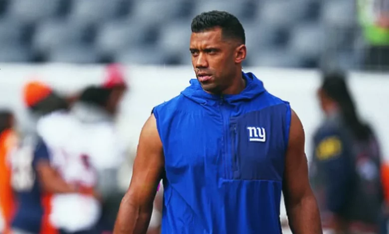 NFL quarterback Russell Wilson stands on the sideline during a preseason game