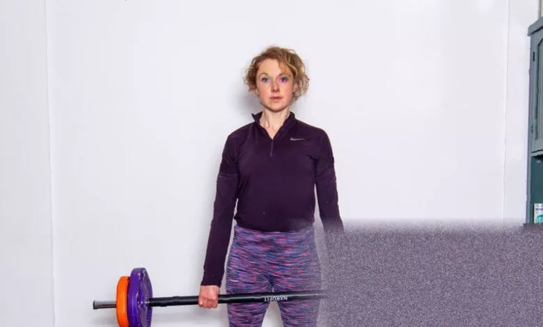 A woman lifting heavy weights in a gym, with focus on proper form during strength training