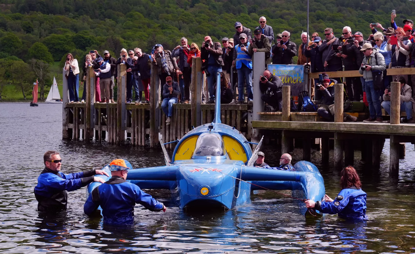 Onlookers cheering from the lakeside as the jet-powered vessel makes its first public run