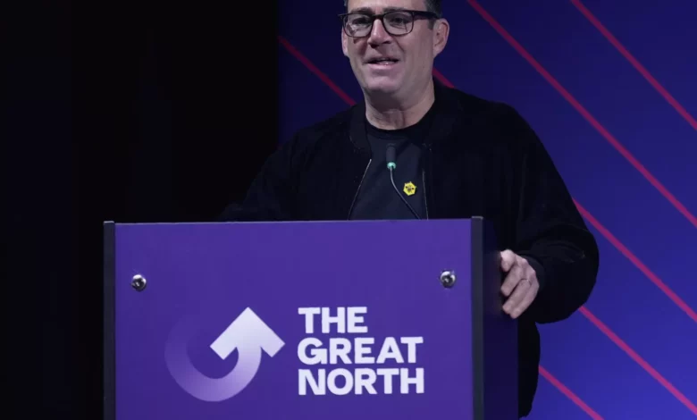 A press conference in Leeds where a politician speaks at a podium with European Union flags behind him.