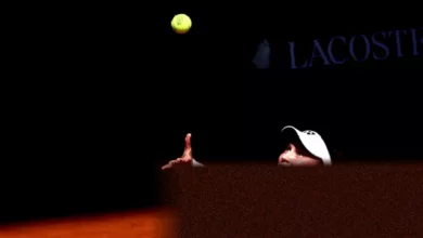 Iga Swiatek serving on a packed Philippe-Chatrier court during the French Open