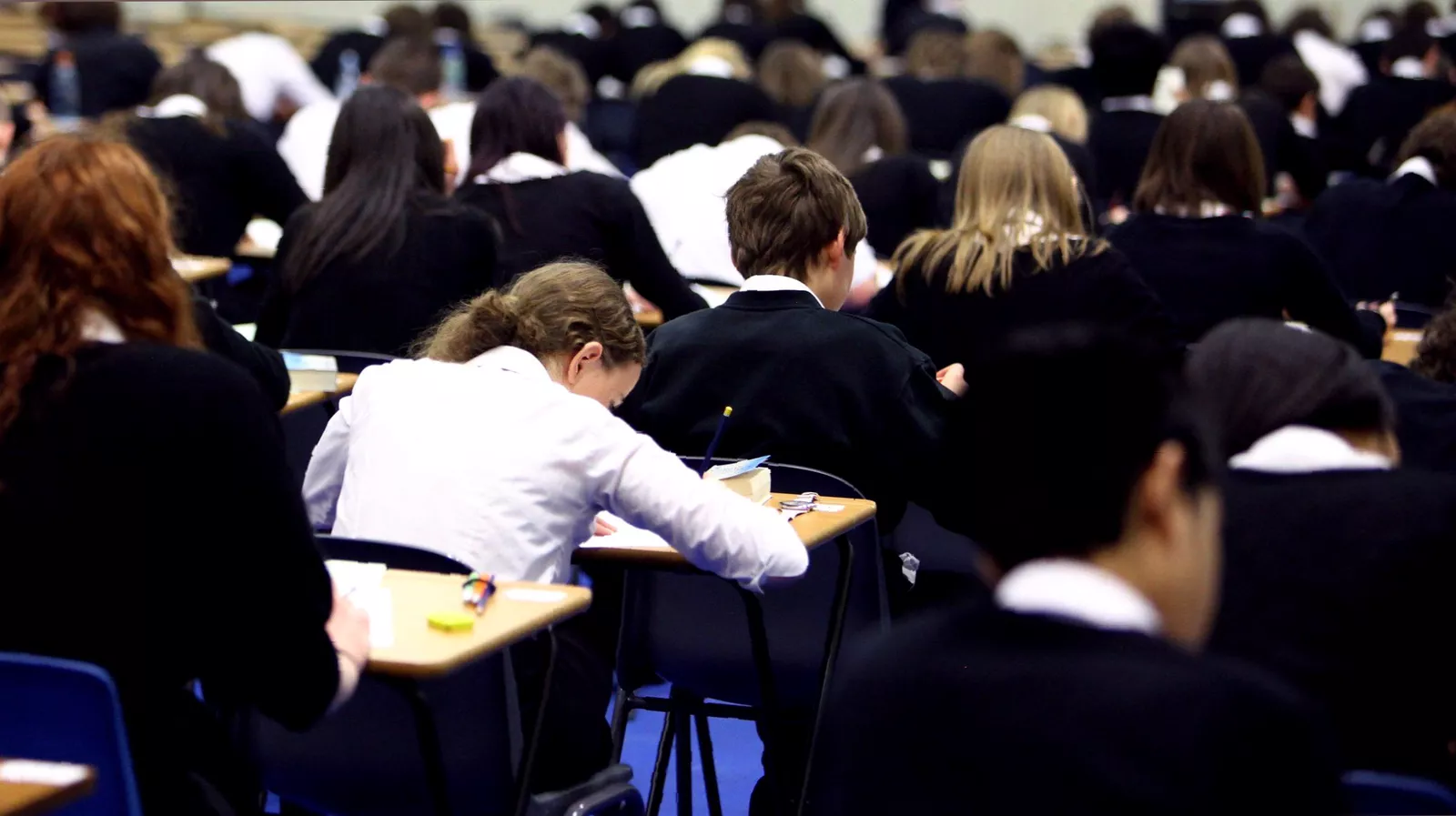 A maths teacher writing equations on a whiteboard during a revision lesson