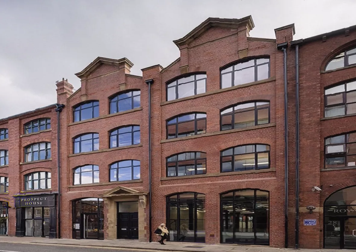 Interior shot of a refurbished office floor with exposed brickwork and cast iron columns