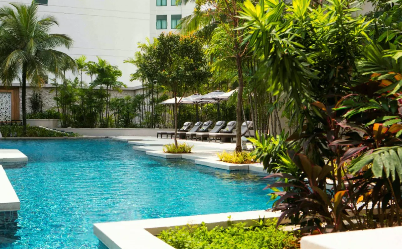 Outdoor swimming pool and sun loungers at a luxury city hotel