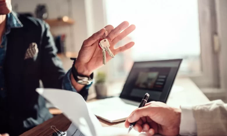 A landlord reviews a tenancy agreement at a desk with property documents.
