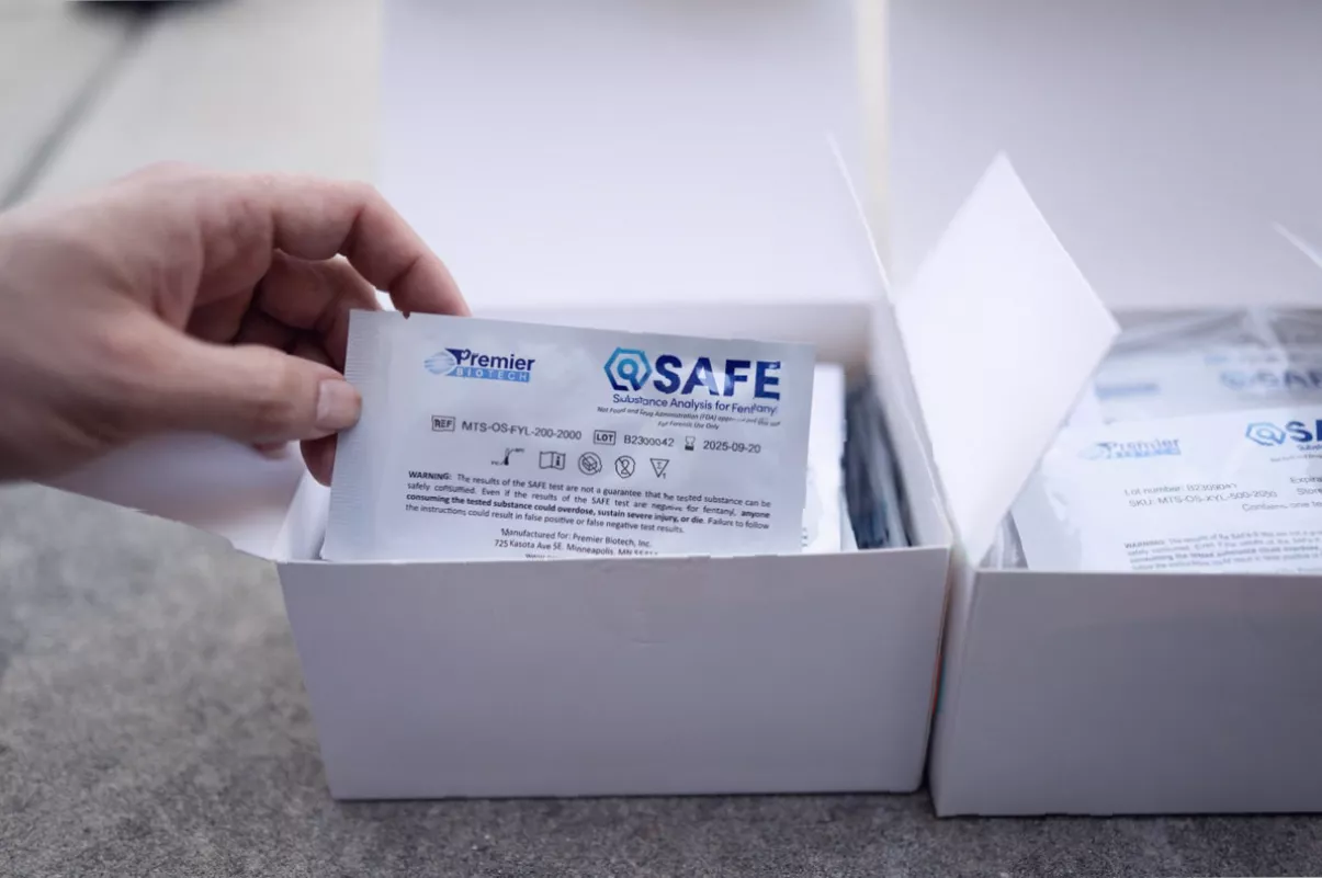 Packages of naloxone nasal spray on a pharmacy shelf