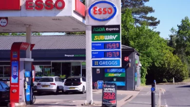 A petrol station forecourt showing a price display board with fuel costs above 150p per litre.