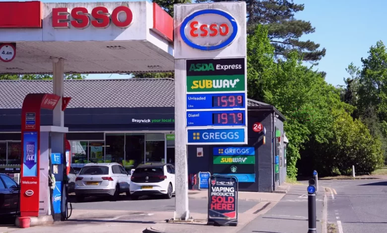 A petrol station forecourt showing a price display board with fuel costs above 150p per litre.