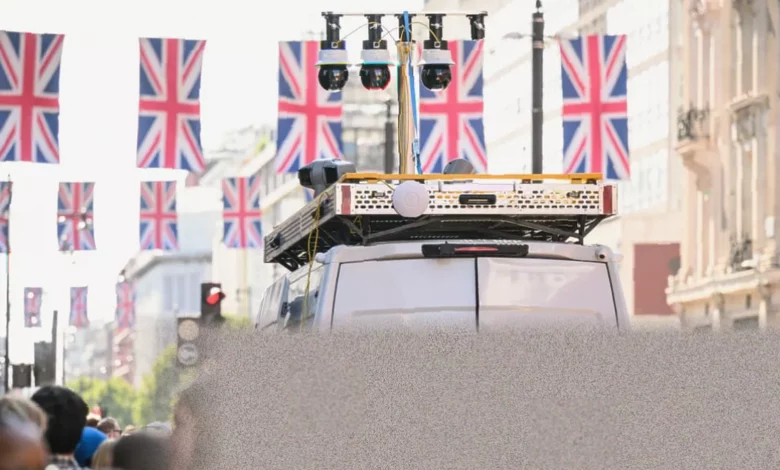 A street-mounted police camera scanning passers-by in a busy UK city centre.