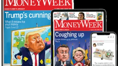 Stack of MoneyWeek financial magazines on a desk with a coffee cup