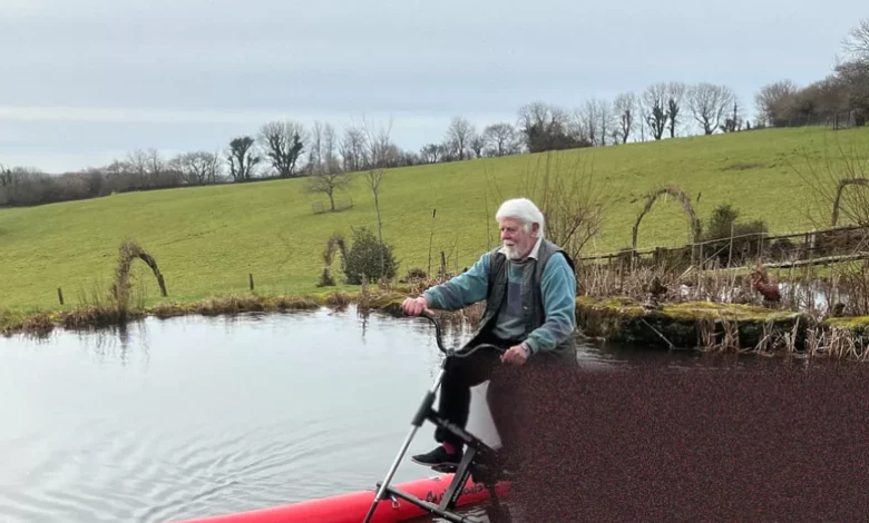 Elderly activist pedals a water-bike on the River Thames near Oxford