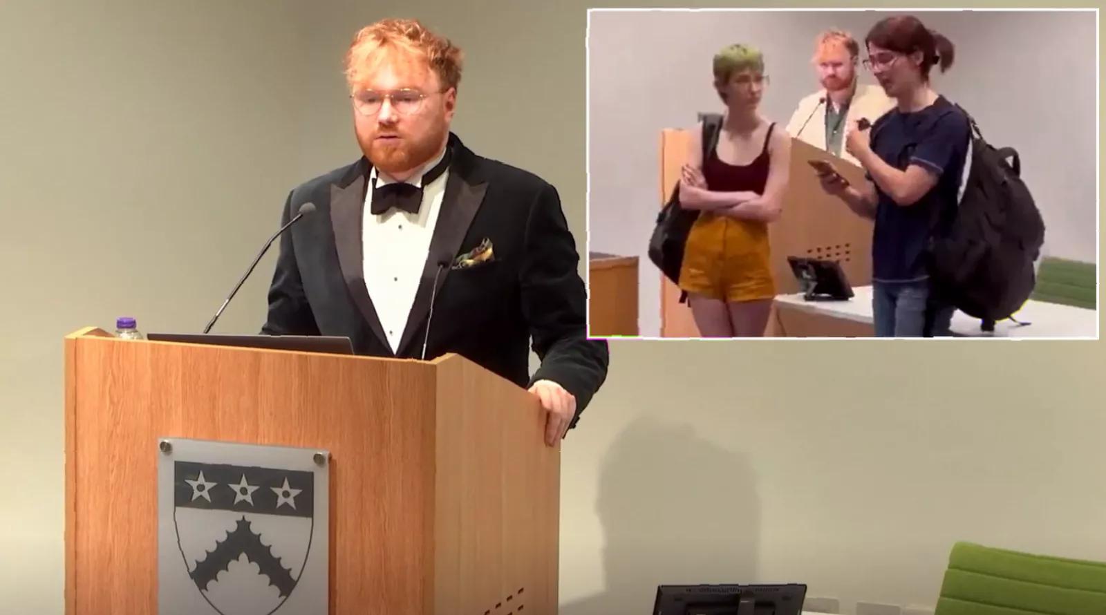 Protesters holding signs inside an academic hall during a university lecture on gender law