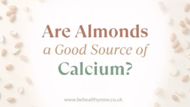 Small handful of almonds on a wooden surface near a glass of cow's milk