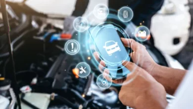A mechanic in a UK garage using a tablet to diagnose a car's engine fault