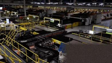 Factory production line with workers assembling machinery under bright industrial lighting