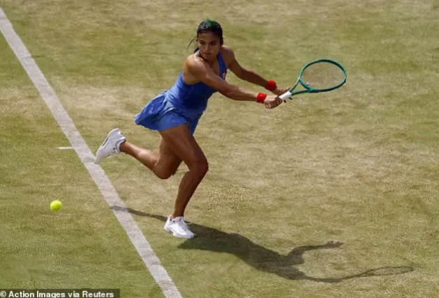 Crowd applauding as a tennis player receives medical attention for a thigh injury.