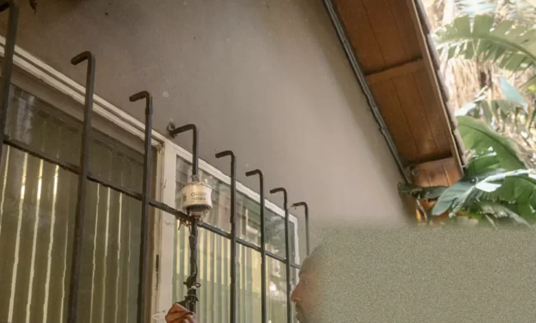 Shoebox-sized air quality sensor mounted on the side of a house in Pacoima.