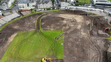 Historic seafront rugby ground with construction fencing and machinery in place