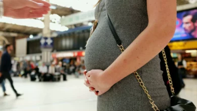 A woman in her forties looking at a pregnancy test in a bright living room