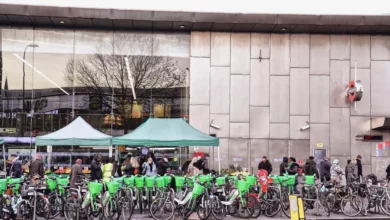 A row of abandoned hire e-bikes lying across a London pavement, blocking pedestrian access.