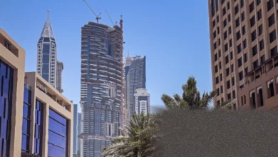 Aerial view of Dubai skyline with Palm Jumeirah and luxury towers under hazy skies