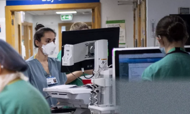 Overcrowded hospital corridor with patients on trolleys lining the walls